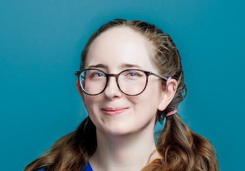 a woman wearing glasses and a blue shirt