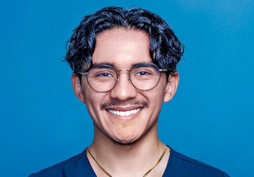 a man wearing a blue shirt and glasses