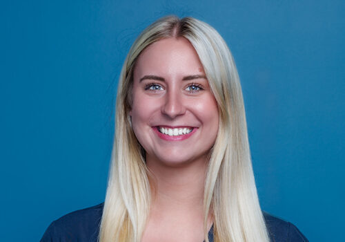 a woman with long blonde hair wearing a blue shirt