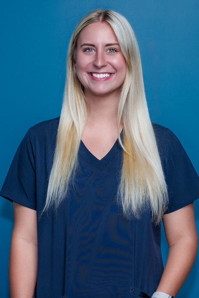 a woman with long blonde hair wearing a blue shirt