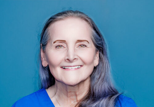 a woman in blue scrubs smiling