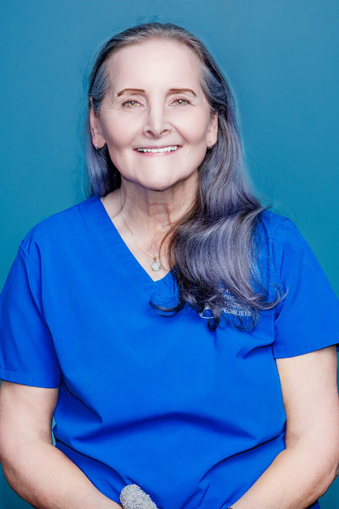 a woman in blue scrubs smiling